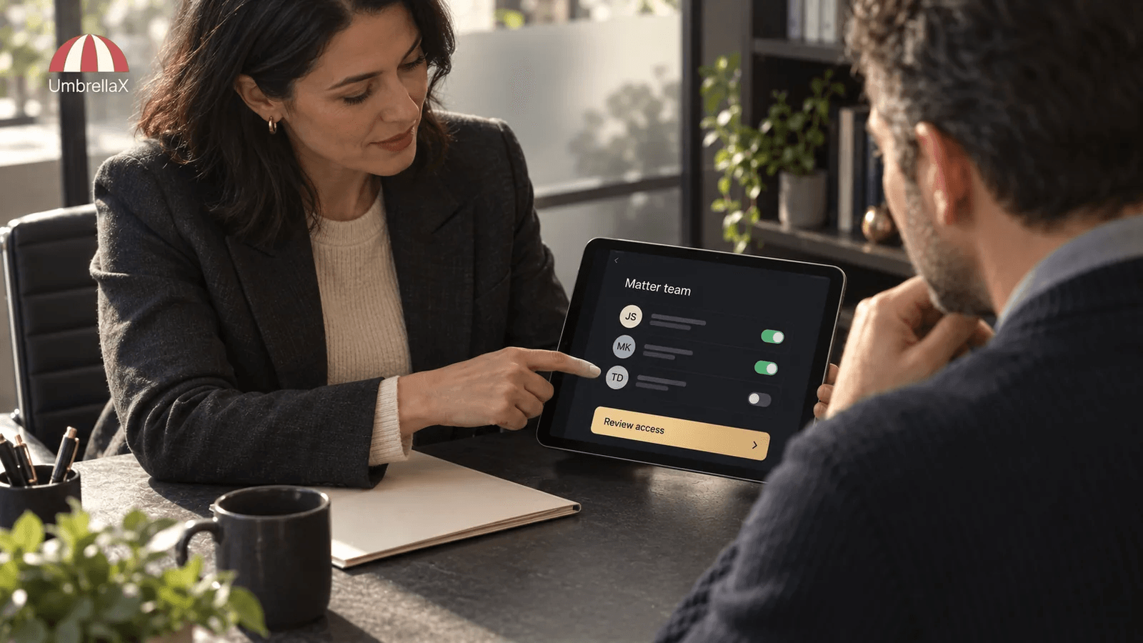 A lawyer and client review a confidential matter team on a tablet.